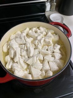 a red pot filled with food on top of a stove