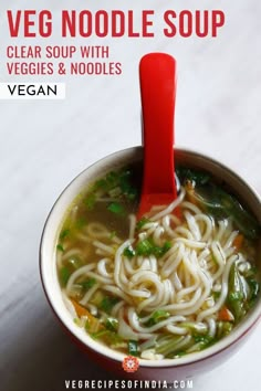 a red spoon is in a bowl of soup with noodles and vegtables