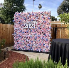 a flower covered wall in the middle of a garden