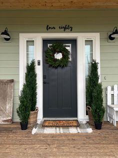 the front door is decorated for christmas with wreaths and potted plants