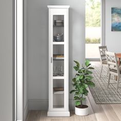 a white cabinet with glass doors in a dining room