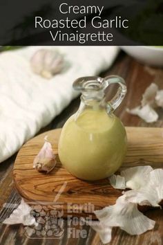 a bottle of creamy roasted garlic vinaigrete on a cutting board with leaves