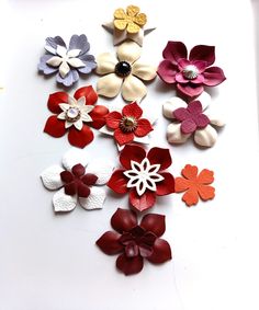 a bunch of different colored flowers on a white surface