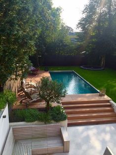 an aerial view of a backyard with a pool and stairs leading up to the house