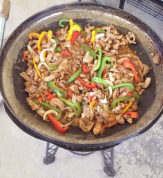 a pan filled with meat and peppers on top of a table