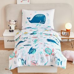 a bed with a blue whale comforter and pillows