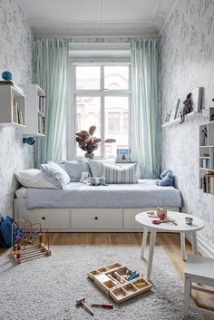 a room with a bed, table and shelves in it that have books on them