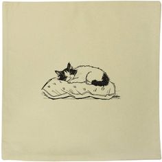 a black and white cat laying on top of a pillow