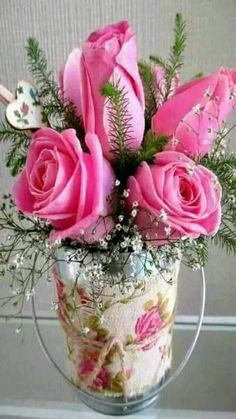 pink roses and greenery in a vase on a table