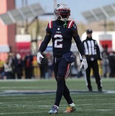 a football player is walking on the field with his hands in his pockets and wearing a helmet