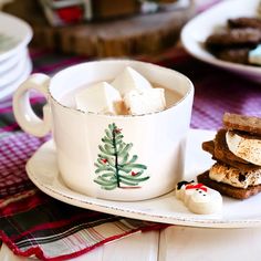 a cup of hot chocolate and marshmallows on a plate