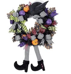 a halloween wreath with black and white striped stockings, witch hat, and pumpkins