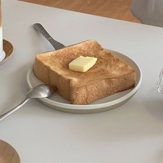 a piece of toast on a plate with butter