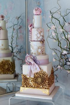 a three tiered cake with flowers and ribbons on it