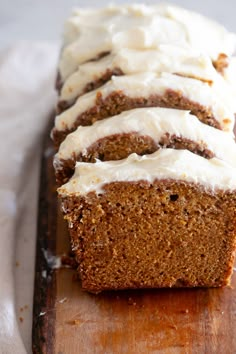 slices of carrot bread with white frosting on a cutting board