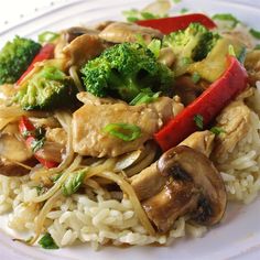 a white plate topped with rice covered in mushrooms and broccoli next to red peppers