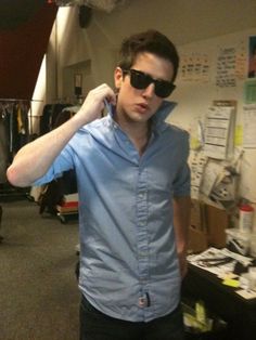 a young man wearing sunglasses in an office