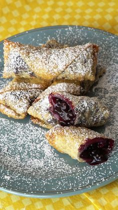 powdered sugar and jelly filled pastries on a plate