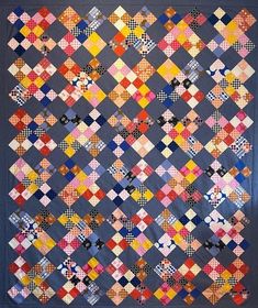 a quilt made with different colored squares on the front and back of it, in various colors