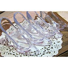 four clear shoes sitting on top of a doily