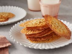 a stack of cookies sitting on top of a white plate next to a glass of milk