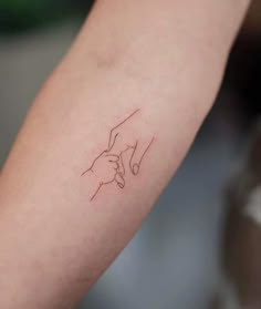 a woman's arm with a tattoo on it that has the outline of a hand holding an object