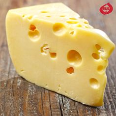 a piece of cheese sitting on top of a wooden table