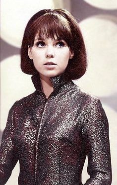 a woman with short hair wearing a shiny jacket