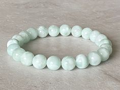 Beautiful, calming pale green moonstone stretchy bracelet. This bracelet is made with 8mm green moonstone beads and pre-stretched, double elastic cord for strength and durability.   ---All bracelets are 7 inches, unless specified.   ---Please message me if you would like a smaller or larger size. This would make a nice gift or addition to your own jewelry collection.   SIZING: PROPER MEASUREMENT FOR FIT:  Measuring the right length for your bracelet is easy.  Using a flexible tape measure, measure your wrist where you will be wearing your bracelet. If you don't have a tape measure, a piece of yarn or string will work.  Measure the circumference and then lay the string down on a ruler or tape measure to get your wrist size.  Easy!  It is suggested to add an additional 0.5 inch to ensure a c Moonstone Stretch Bracelet With Round Beads, Adjustable Green Crystal Bracelet With 8mm Beads, Hand-strung Round Moonstone Beaded Bracelets, Hand-strung Silver Moonstone Beaded Bracelets, Adjustable Hand-strung Moonstone Beaded Bracelet, Green Moonstone, Bracelet Stacking, Moonstone Bracelet, Moonstone Beads