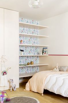 a bedroom with a bed, bookshelf and stuffed animals