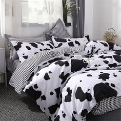 a black and white cow print comforter on a bed