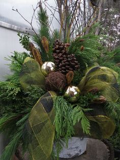 an arrangement of evergreen, pine cones and other greenery