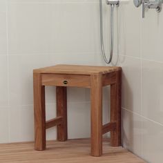 a wooden stool sitting next to a shower head