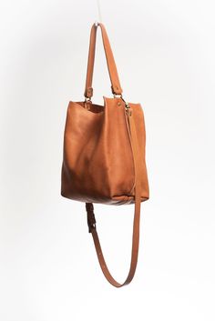 Made with smooth vegetable tanned leather dyed with natural pigmentsrespecting the environment.The Lago is an unlined tote featuring a top handle that can be hand held or used on the shoulder. It also comes with an adjustable and detachable long and slim leather shoulder strap. It has a central compartment with a zipper, and is held shut by a sturdy snap closure.Handcrafted in Argentina by artisans in small batches, with every detail taken care of.Dust bag included for proper storage. Cognac Leather Shoulder Bag With Handle Drop, Everyday Cognac Shoulder Bag With Detachable Strap, Leather Backpack With Detachable Handle For Daily Use, Leather Bucket Hobo Bag, Leather Bucket Hobo Bag With Handle Drop, Everyday Cognac Bucket Bag With Detachable Strap, Everyday Leather Handle Bucket Satchel, Leather Hobo Bag With Detachable Strap For Everyday, Leather Bucket Bag With Handle Drop For Daily Use