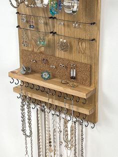 a wall mounted jewelry rack with lots of necklaces hanging from it's sides