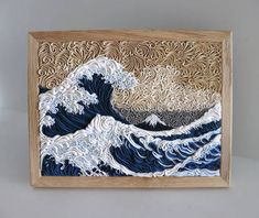 an intricately carved wood panel depicting the great wave in blue, white and brown