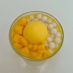 a glass bowl filled with fruit and ice cream on top of a white countertop