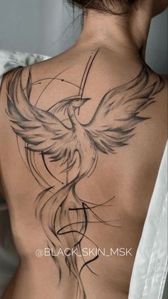 a woman's back with a bird tattoo on it