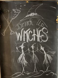 a chalkboard sign that says drink up witches