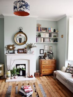 a living room filled with furniture and a fire place in front of a mirror on the wall