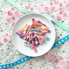 a white plate topped with lots of colorful sprinkles next to a blue ribbon