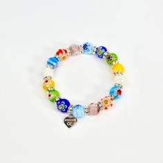 Get ready for the ultimate in wrist candy with the Murano Glass Millefiori Beaded Elastic Bracelet, straight from the famed glass-makers of Murano, Italy - an island near Venice with a long history of glassmaking. Elastic bracelets slip on easily, and fit most wrists. Small bead measures 0.25" in diameter. Bracelet measures approximately 6.5". Large bead measures 0.35" in diameter. Bracelet measures approximately 7". The larger bead bracelet shown in the photos here is our clasped Millefiori lar Adjustable Murano Glass Beaded Bracelets With Round Beads, Adjustable Murano Glass Beaded Bracelets, Spiritual Multicolor Bracelets With Heart Beads, Colorful Glass Beads Bracelets Gift, Colorful Glass Beads Stretch Bracelet As Gift, Colorful Glass Bead Bracelets As Gift, Adjustable Murano Glass Beaded Bracelets As Gift, Glass Beaded 8mm Bracelets As Gift, Colorful Beaded Glass Crystal Bracelet Gift