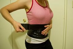 a woman is holding her belt in front of her stomach