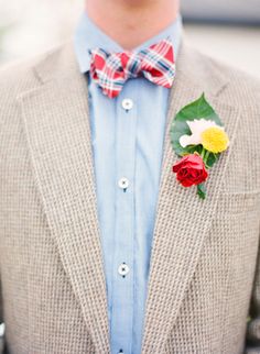 a man wearing a bow tie and a jacket with flowers on it's lapel