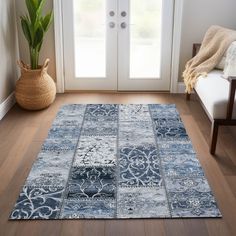 a blue area rug in front of a door with a potted plant on the floor