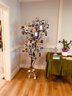 there is a tree with pictures on it in the corner next to a green table