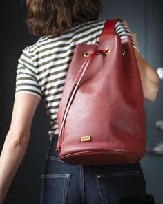 Oxblood shade bucket bag made of genuine leather, pre-owned vintage. The main closure is with drawstrings. Pocket with zipper on the backside. Black textile lining inside. Good condition backpack.   Brand: Gianfranco Ferre Made in Italy The measurements are taken with the bag empty, laying flat out and at the widest point. OUTSIDE DIMENSIONS Height: 15.3" (39 cm Width: 13.7" (35 cm) Bottom wide: 8.2" (21 cm The shoulder strap is about 28.7" (73 cm) long NOTE: All bags in my shop are vintage whic Vintage Red Hobo Bag For Everyday Use, Vintage Burgundy Shoulder Bag With Adjustable Strap, Vintage Red Soft Leather Bags, Trendy Handbag, Red Leather Shoulder Bag With Gold-tone Hardware, Red Leather Bag With Gold-tone Hardware, Vintage Crossbody Bag, Vintage Backpacks, Dark Burgundy