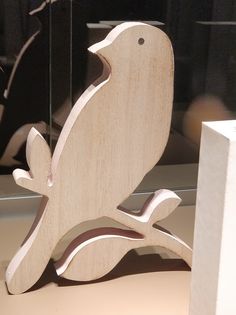 a wooden bird sitting on top of a table