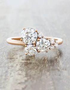 three stone diamond ring sitting on top of a table