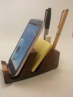 a cell phone sitting on top of a desk next to a pen and pencil holder